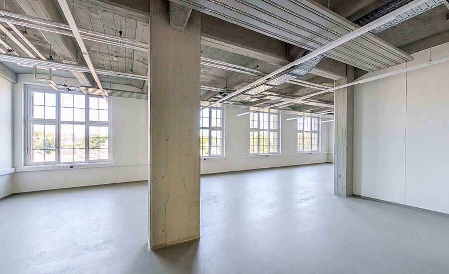 Lichtdurchflutete Werkstatt ohne Ausstattungen, mit einer auffälligen Säule im Zentrum des Raumes