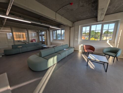 Lichtdurchflutete Lobby mit gemütlichen, farbenfrohen Möbeln und einer warmen, einladenden Atmosphäre