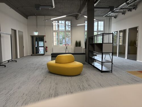 Ein gemütlicher Raum, ausgestattet mit komfortablen Sesseln und modernen Möbelstücken, ideal für Entspannung und Geselligkeit