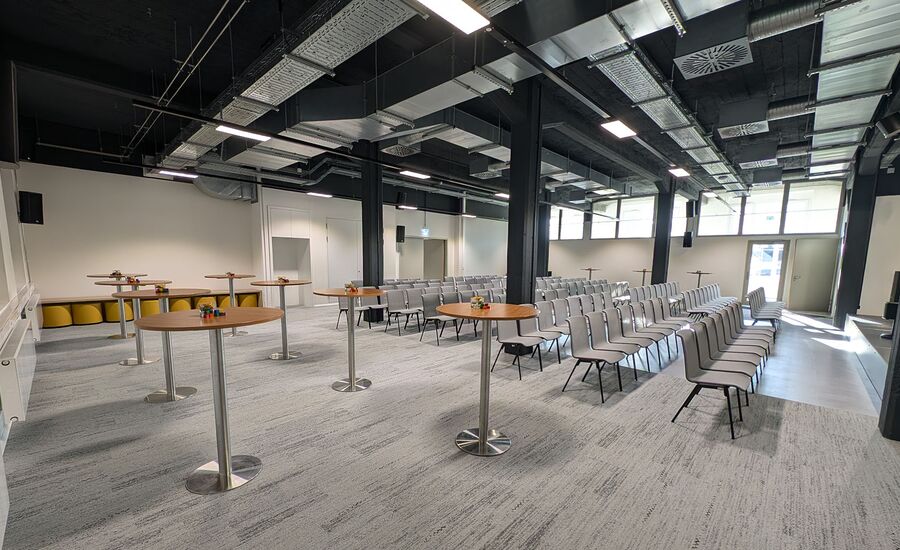 Konferenzraum mit Reihenbestuhlung und Stehtischen an der Seite