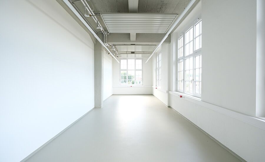 Leeres Atelier mit großen Fenstern und viel Raum